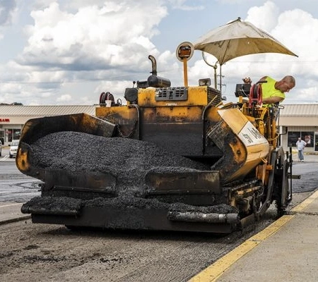 PaveConnect team member applying a fresh layer of asphalt to a retail parking lot for asphalt repairs